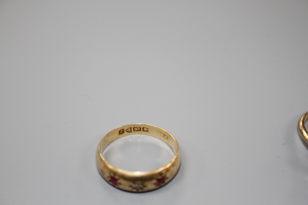 An early 20th century 18ct gold and gypsy set ruby and diamond three stone ring and one other ring.
